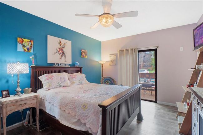 Bedroom with a closet, wood finished floors, baseboards, and ceiling fan | Image 12