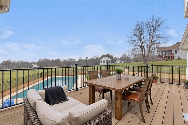 Wooden terrace featuring a fenced in pool, outdoor dining space, outdoor lounge area, and a lawn | Image 21
