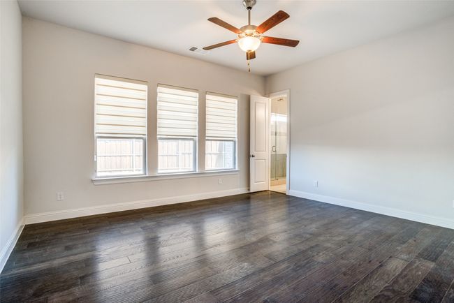 Empty room with a ceiling fan and dark wood-style flooring | Image 16