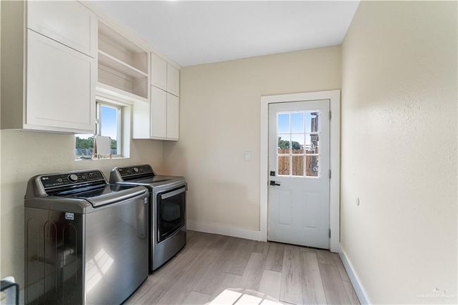 Washroom with separate washer and dryer, cabinets, and light hardwood / wood-style flooring | Image 14