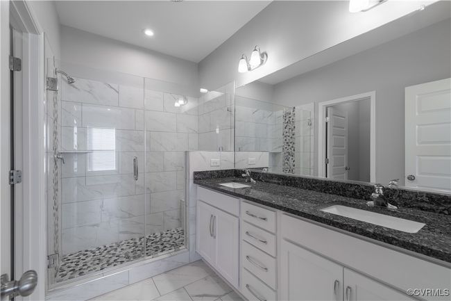 Bathroom with a shower with shower door, dual bowl vanity, and tile flooring | Image 10