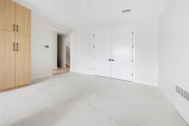 Unfurnished bedroom with radiator heating unit and a closet | Image 29