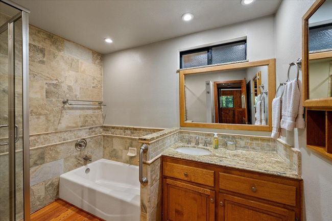 Updated downstairs main bathroom with granite counter and tiled surround | Image 38