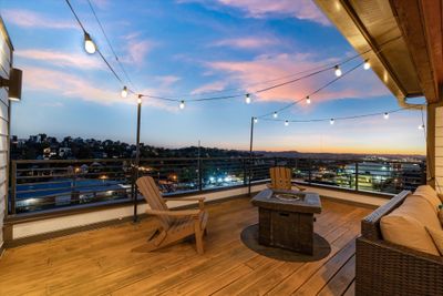 Gorgeous sunset views of the western hills from the top deck, where you'll also find a covered lounge/tv area that's perfect for movie night. | Image 1