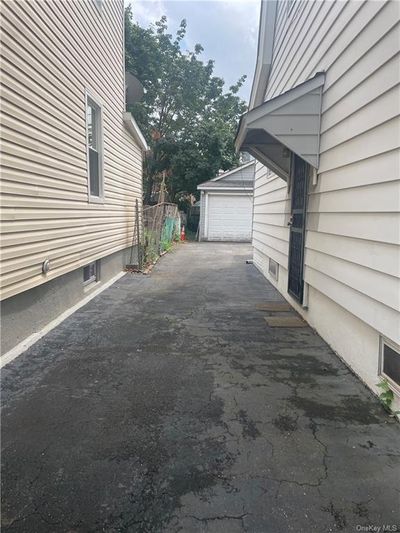 View of property exterior featuring an outdoor structure and a garage | Image 2