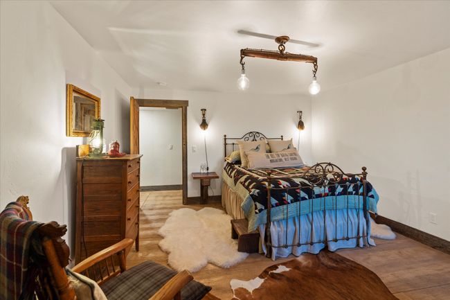 o bedrooms with huge closets and antique wrought iron beds in the basement along with spacious laundry closet and full bath with walk-in shower complete this peaceful charming home in the woods | Image 38