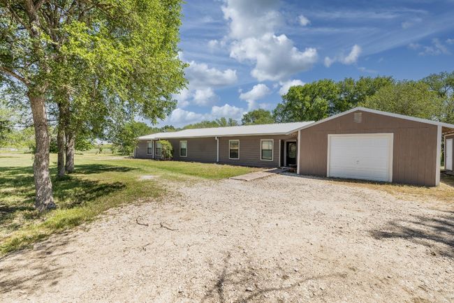 Ranch-style home featuring dirt driveway and an attached garage | Image 26