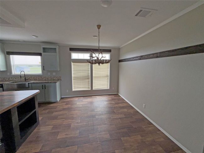 Kitchen with a chandelier, crown molding, pendant lighting, and recessed lighting | Image 5