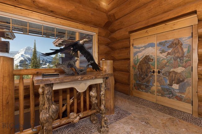 Main level entryway with view of Lone Mountain and custom carved/painted double doors to Primary Suite. | Image 12