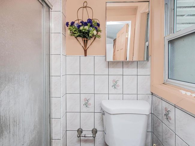 Bathroom with tile walls and toilet | Image 6