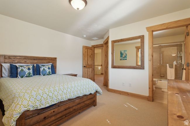 Carpeted bedroom featuring baseboards, connected bathroom, and radiator heating unit | Image 39