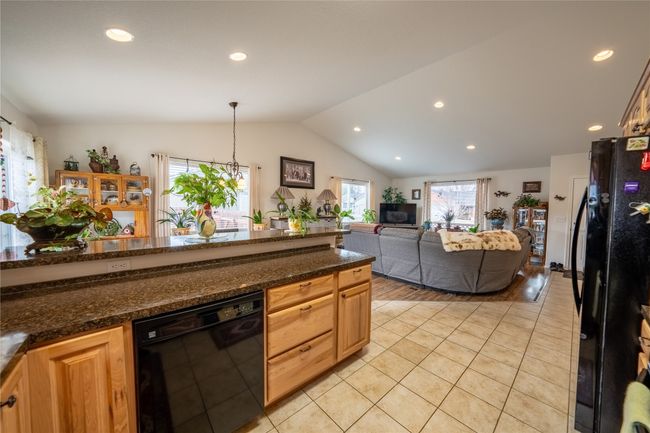 Kitchen featuring open floor plan, lofted ceiling, recessed lighting, light tile patterned flooring, and black appliances | Image 5