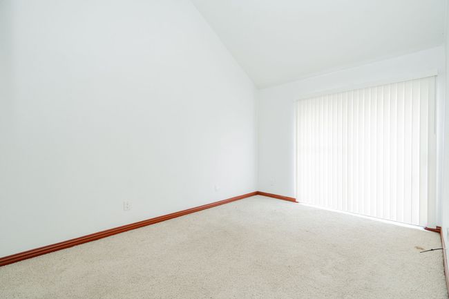 Carpeted empty room featuring vaulted ceiling and baseboards | Image 9