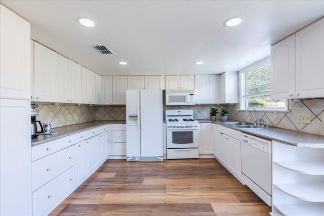Kitchen featuring white appliances and cabinetry. | Image 8