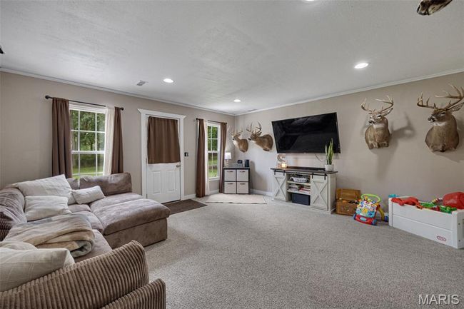 Carpeted living room featuring healthy amount of natural light, crown molding, recessed lighting, and baseboards | Image 4