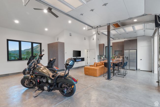 Garage featuring stainless steel refrigerator with ice dispenser, recessed lighting, and a ceiling fan | Image 73