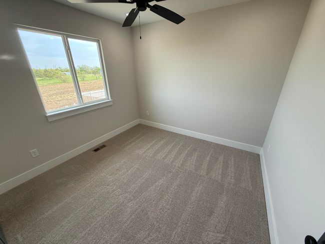 Carpeted empty room with a ceiling fan and baseboards | Image 10