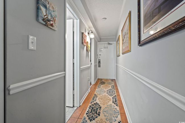 Hall with light tile patterned flooring, a textured ceiling, baseboards, and ornamental molding | Image 29