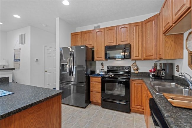 Warm wood cabinets and contrasting countertops add interest to the space. | Image 13