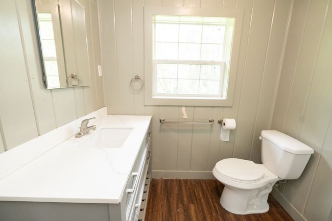 Half bath featuring wood finished floors, a decorative wall, and vanity | Image 23