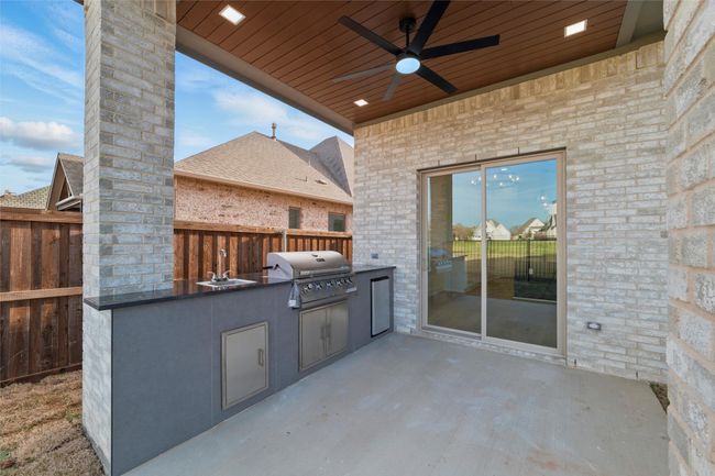 View of patio / terrace featuring ceiling fan, area for grilling, refrigerator, sink and fence | Image 36