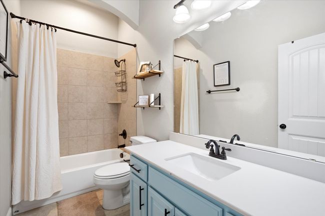 Bathroom with toilet, shower / bathtub combination with curtain, and vanity | Image 8