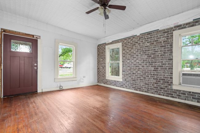 Entryway featuring hardwood / wood-style floors, brick wall, a ceiling fan, healthy amount of natural light, and baseboards | Image 12
