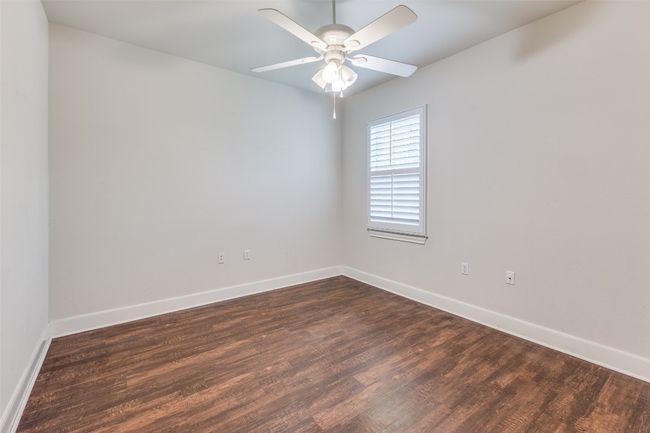 Spare room with baseboards, dark wood-style floors, and ceiling fan | Image 19