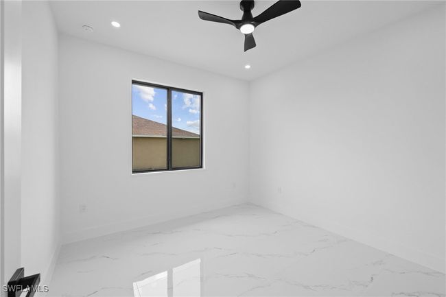 Spare room featuring baseboards, marble finish flooring, recessed lighting, a ceiling fan, and a smoke detector | Image 15