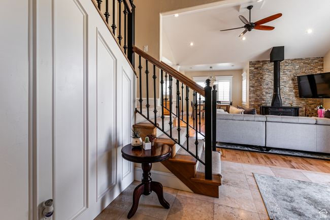 Stairway with vaulted ceiling, recessed lighting, a wood stove, a ceiling fan, and stone tile flooring | Image 26