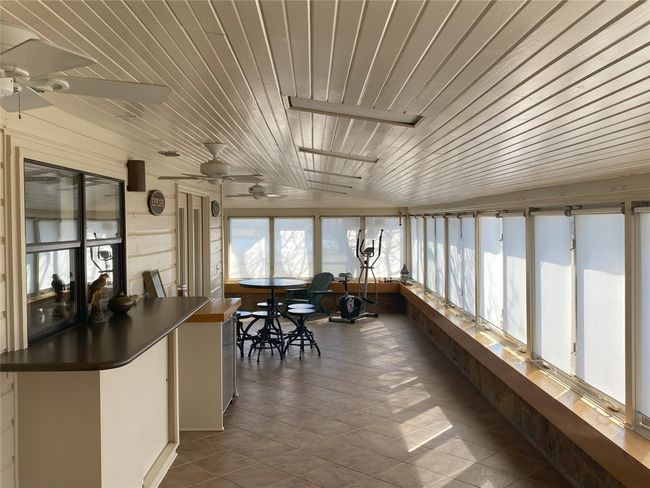 Sunroom / solarium with wooden ceiling and ceiling fan | Image 5