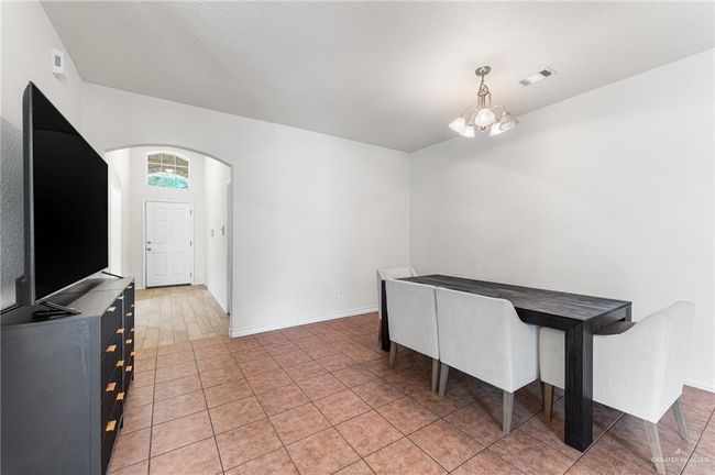 Unfurnished dining area featuring arched walkways and a chandelier | Image 23