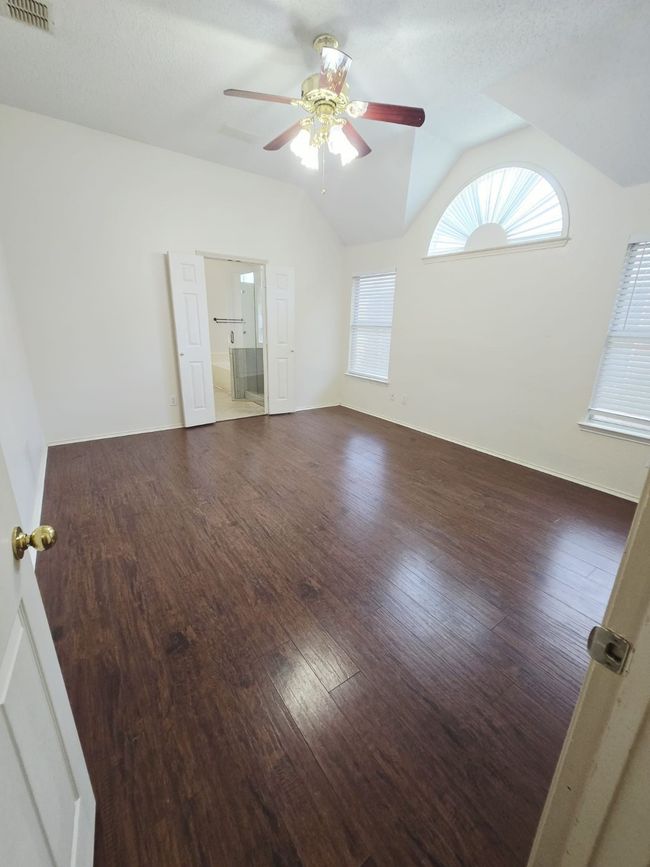 Unfurnished room featuring a ceiling fan, lofted ceiling, and wood finished floors | Image 4