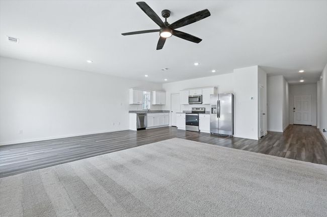 Living area with recessed lighting, dark wood finished floors, and a ceiling fan | Image 7