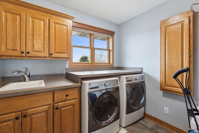 Upper level laundry with built in storage and tile floors | Image 23