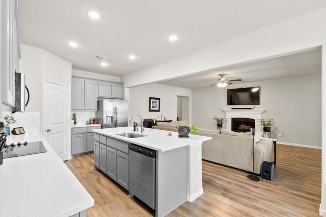 Kitchen with gray cabinetry, a ceiling fan, light countertops, stainless steel appliances, and light wood finished floors | Image 9