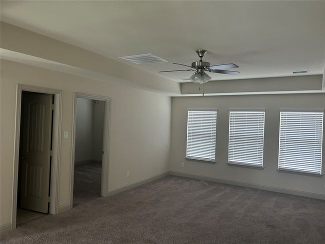 Carpeted empty room with a ceiling fan and baseboards | Image 11