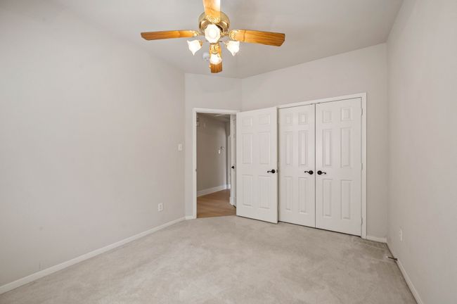 Unfurnished bedroom featuring light colored carpet, a closet, ceiling fan, and baseboards | Image 29