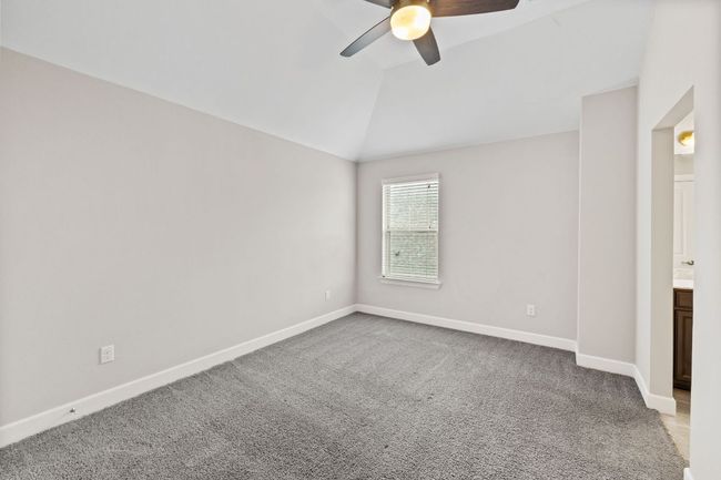 Carpeted spare room featuring ceiling fan, vaulted ceiling, and baseboards | Image 28