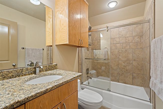 Full bathroom featuring vanity, bath / shower combo with glass door, and toilet | Image 27