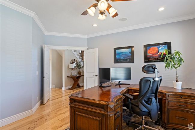 Office area featuring light wood-style floors, crown molding, baseboards, and ceiling fan | Image 27