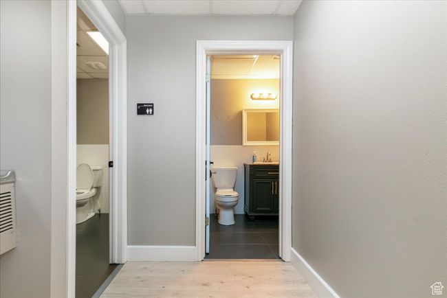 Hallway featuring light wood-style flooring and a drop ceiling | Image 15