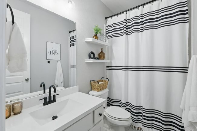 Bathroom featuring vanity and curtained shower | Image 17