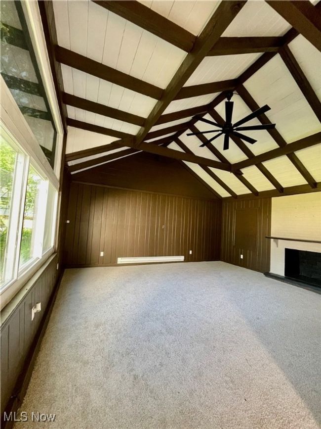 Bonus room featuring carpet floors, wood walls, and a fireplace | Image 13