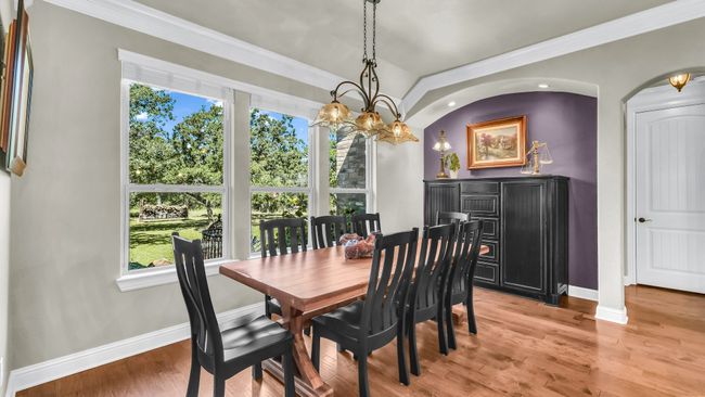 Dining room with light wood-style floors, ornamental molding, arched walkways, and a chandelier | Image 24
