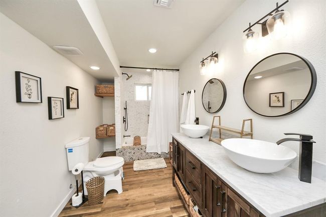 Enjoy double sinks, an oversized vanity, and abundant storage in this beautifully updated primary bathroom. | Image 17