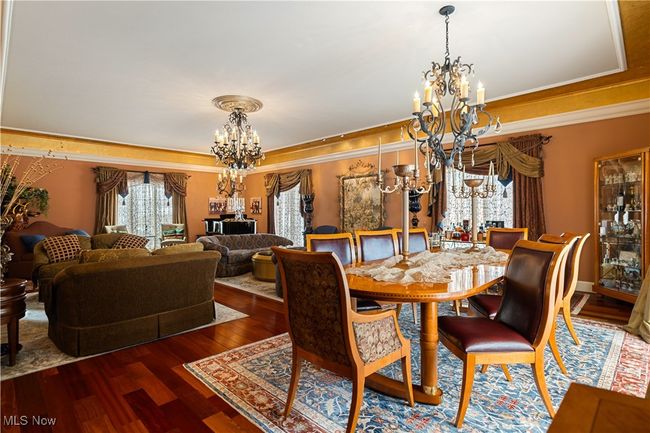Dining area with a chandelier, crown molding, and wood finished floors. | Image 22