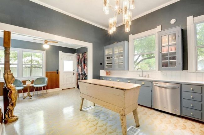 Kitchen with dishwasher, gray cabinetry, light flooring, light countertops, and a wainscoted wall | Image 13