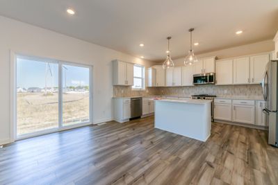 (Photo is of an inventory home, actual homes finishes will vary) Soaked in natural sunlight, the homes eat-in dining room has ample space for a dining table located in the heart of the home. | Image 3