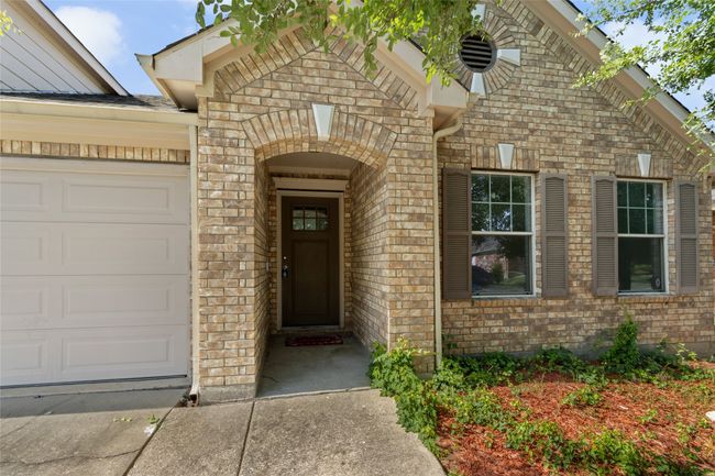 View of exterior entry featuring brick siding and a garage | Image 4